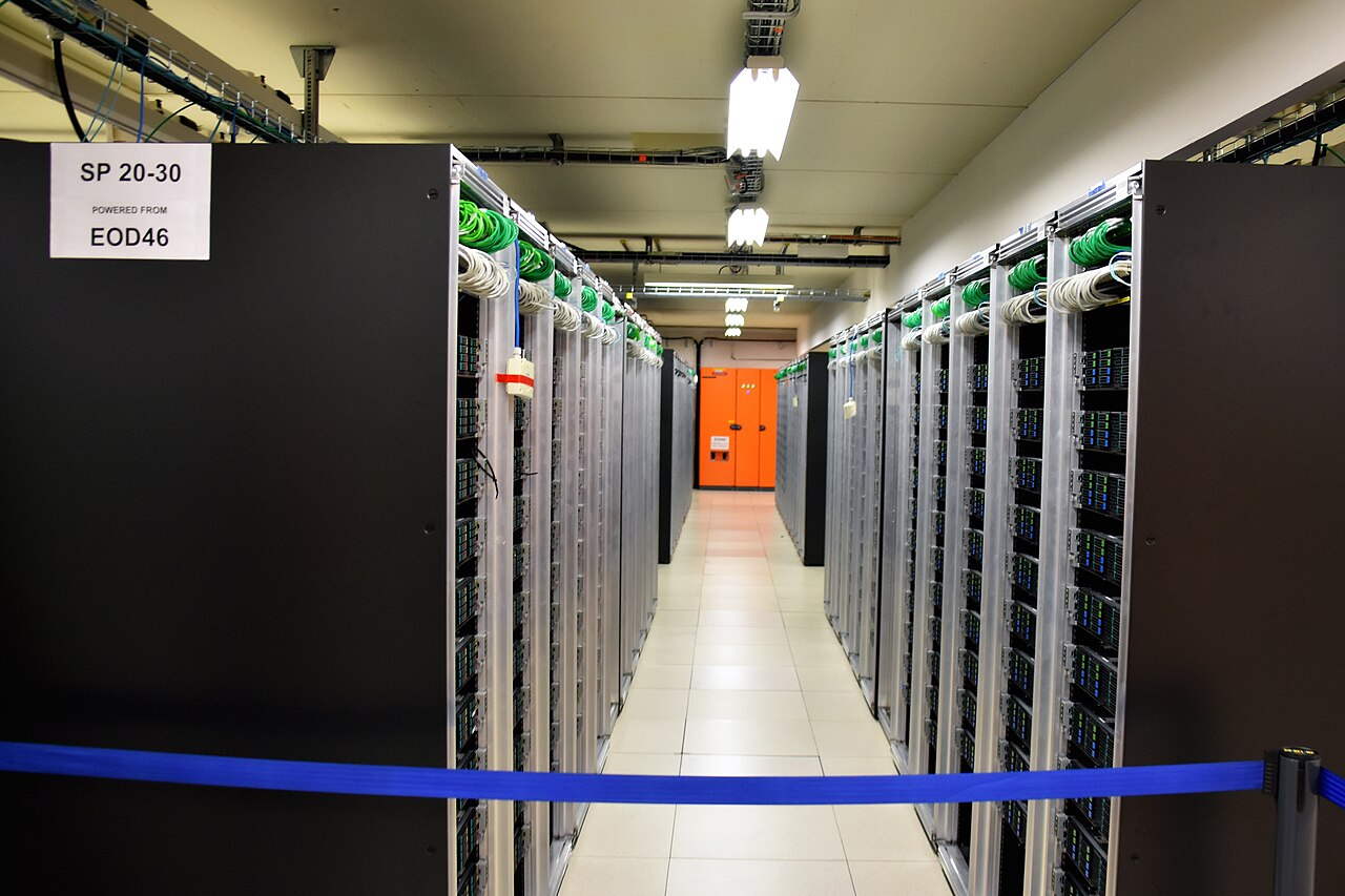 A brightly lit corridor of modern server racks